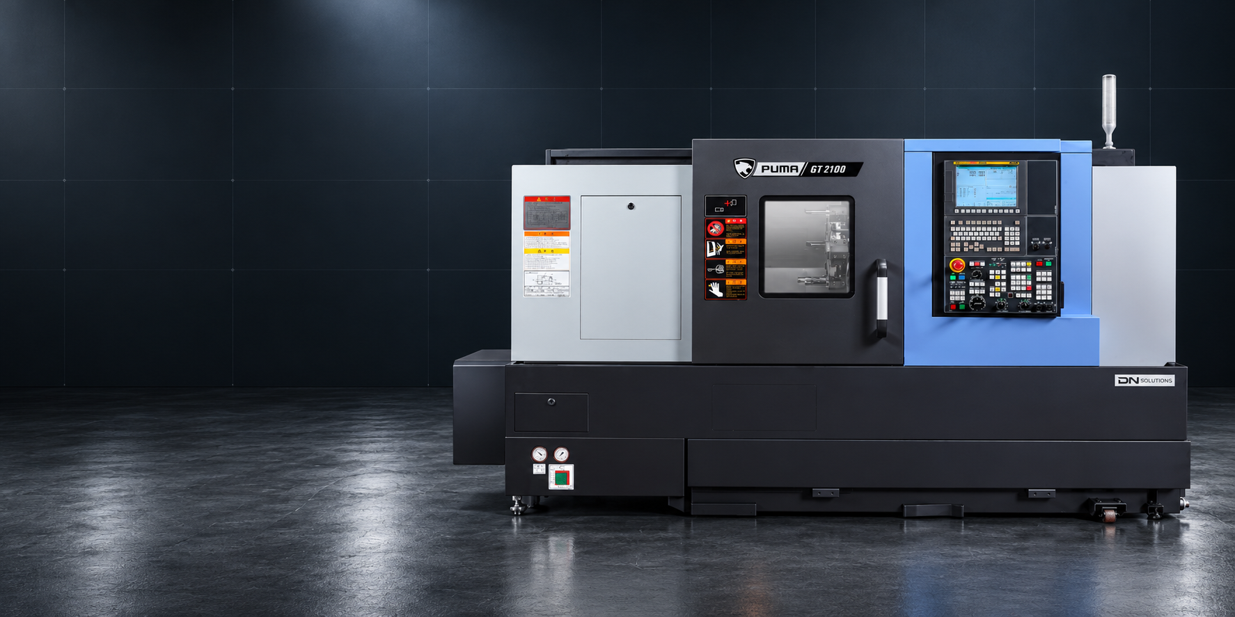 Koyu endüstriyel zemin önünde DN Solutions Puma GT2100B CNC torna tezgâhının temsili görseli